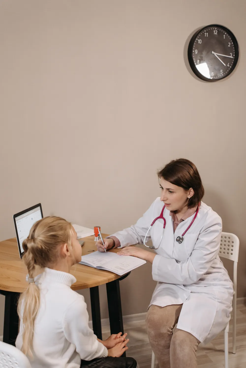 A clinician talking with a child during a consultation